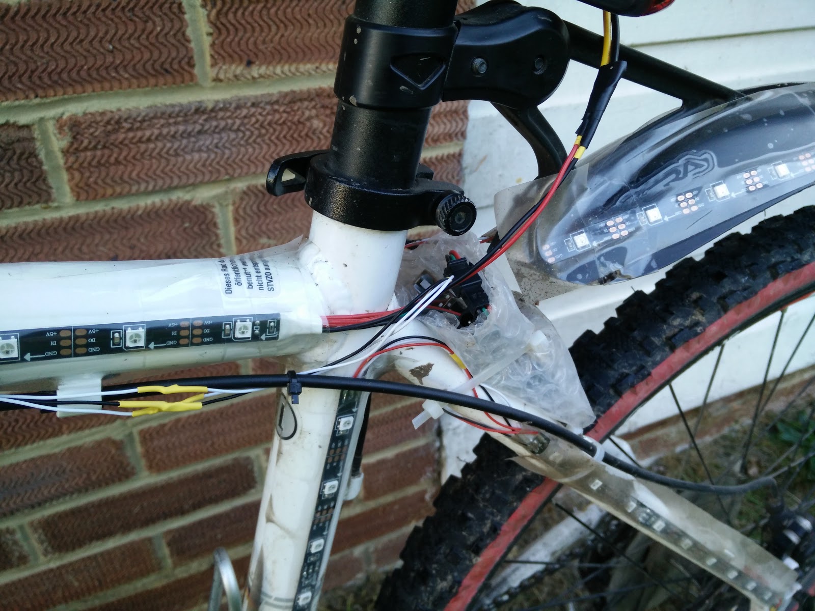 The Arduino, nestled in some bubble wrap, attached with some more cable ties, and also some tape.